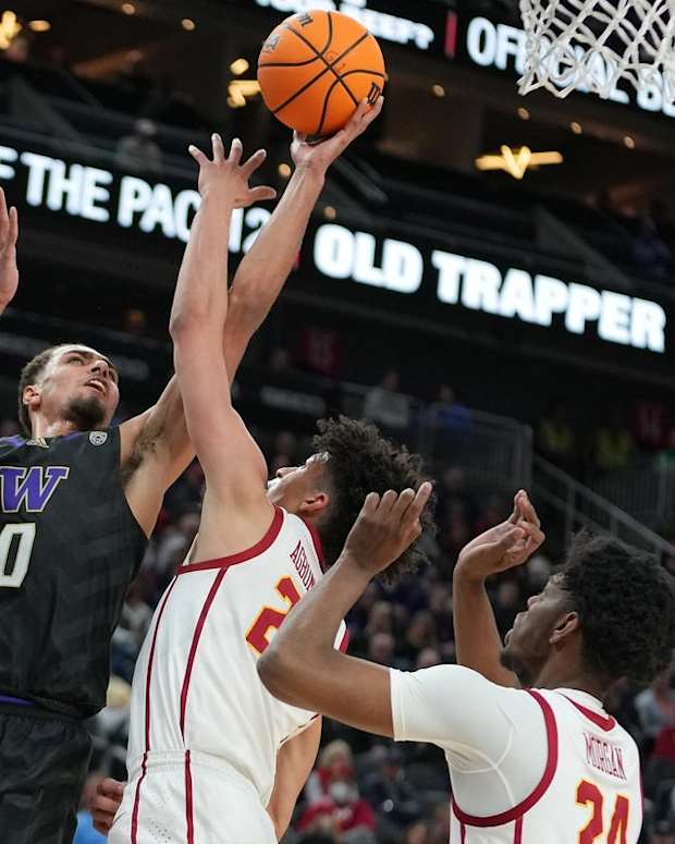 Mar 10, 2022; Las Vegas, NV, USA; Washington Huskies forward Emmitt Matthews Jr. (0) shoots against USC Trojans forward Max Agbonkpolo (23) and USC Trojans forward Joshua Morgan (24) during the first half at T-Mobile Arena. Mandatory Credit: Stephen R. Sylvanie-USA TODAY Sports
